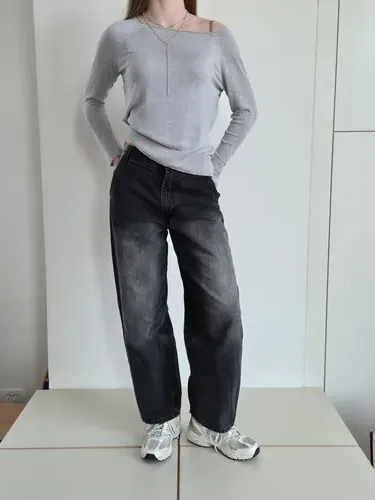 Športen pulover, ki ima eleganten okras s pozlačenimi gumbi na rokavu. 